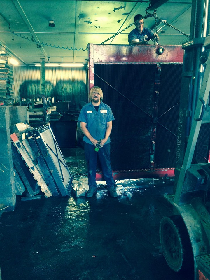 Melcot Radiator technicians with a large truck radiator core on the shop floor